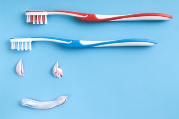 Red and blue toothbrushes and colorful toothpaste shapes
