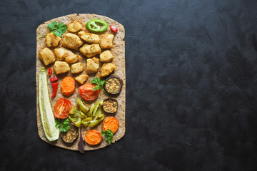 Pieces of fried chicken fillet in tortilla bread with grilled vegetables.