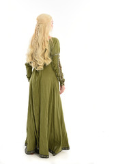 Fototapeta na wymiar full length portrait of blonde girl wearing green medieval gown, standing pose facing away from camera. isolated on white studio background.