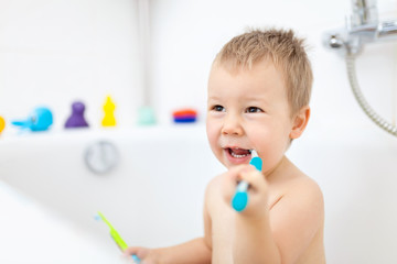 Adorable child learing how to brush his teeth