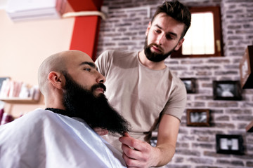 Master makes beards correction in barbershop salon