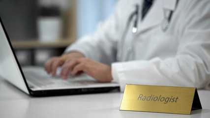 Fototapeta premium Radiologist filling out medical documentation in clinic, completing report