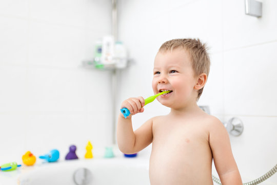 Adorable child learing how to brush his teeth