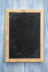 Blank vintage chalkboard on blue wood wall
