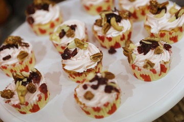 Set of cupcakes around a wedding table. A cupcake is a small cake designed to serve one person and uses ingredients as butter, sugar, eggs, and flour, as well as raisins, nuts, or chocolate chips.
