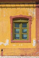 Yellow house with orange details and a window