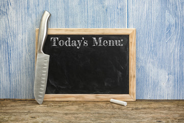 Todays menu written on chalkboard with chef's knife