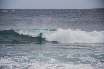 Naklejka premium typical windy day in gran canaria, canary islands, spain. ideal for surfing, bigger waves in the sea, turquoise blue water in the ocean