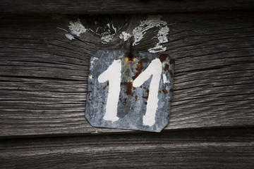Metal plate with number 11 attached to a wooden base