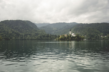 beautiful place called lake bled with church, in slovenia, famous tourist attraction, but too many people and commerce