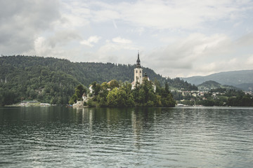 Fototapeta na wymiar beautiful place called lake bled with church, in slovenia, famous tourist attraction, but too many people and commerce