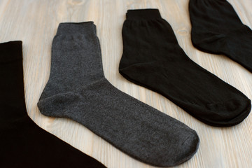 Classic men's socks. Clothes for men. Knitted black and gray socks. Men's socks are spread out on the table.