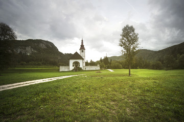 slovenian church in the evening, sun light over the church and the lawn, slovenia state's landmark, typical view for this state