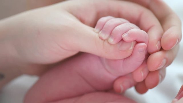 Father and mother holding newborn baby hand. Happy family concept. 4K UHD video 3840X2160