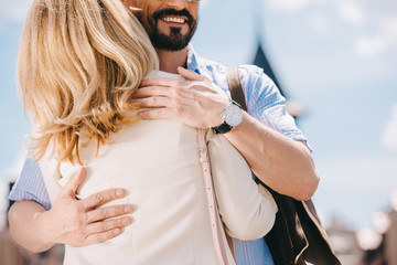 cropped image of adult couple hugging on street