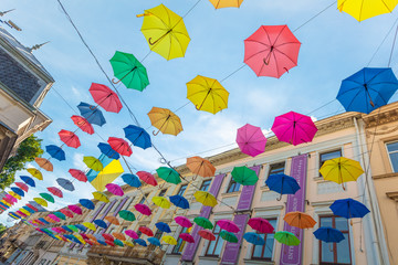 Fototapeta na wymiar Colorful umbrellas hanging on the street in Lviv