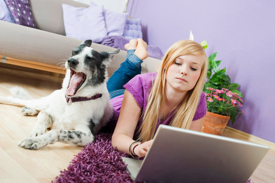 Teenager mit Hund im Wohnzimmer