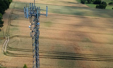 Steel telecommunication tower in the midle of wheat field, aerial view