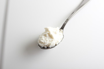 cottage cheese yogurt in a spoon on a white background