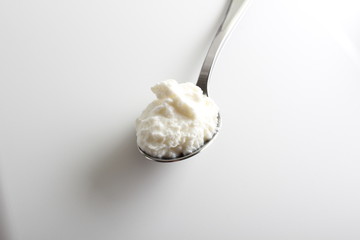 cottage cheese yogurt in a spoon on a white background