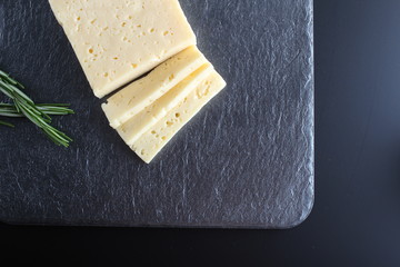 cheese cut on a stone dark background