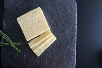 cheese cut on a stone dark background