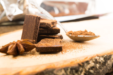 Pieces of chocolate, cinnamon, mint and star anise on the serving Board.