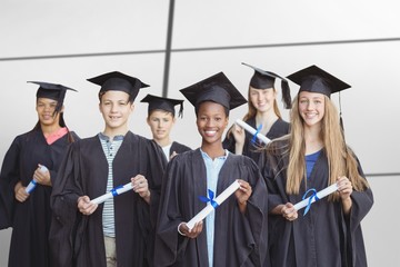 Composite image of portrait of students holding degree