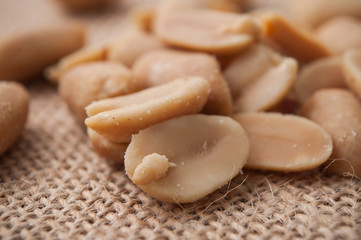 closeup of salted peanuts on hessian background