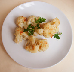 Cauliflower fried in flour and with parsley leaves. Candid.