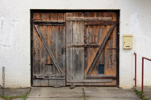 Old Dilapidated Wooden Garage Doors With Rusted Metal Hinges And Old Dilapidated Wooden Garage Doors With Rusted Metal Hinges And Small Mailbox Mounted On Right Side
