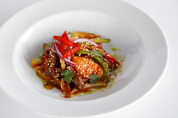 Warm salad with meat and vegetables in a white plate