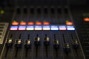 Close up of faders on a digital mixing desk