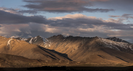 brown mountains with Light and shadow and dramatic sunset clouds on the sky scene in New Zealand