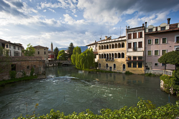 The city of Sacile is mirrored on the river Livenza at sunset. Pordenone district, Italy.