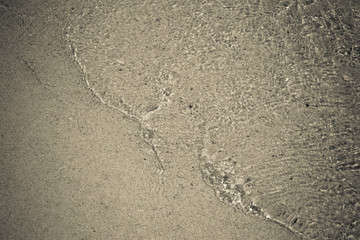 The small waves flowing on the sandy beach