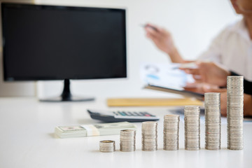 Fototapeta premium Rows of coins for finance and banking concept with business man and woman. A metaphor of international financial consulting.