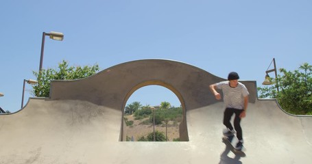 Man skateboarding does extreme grind over quarter pipe 