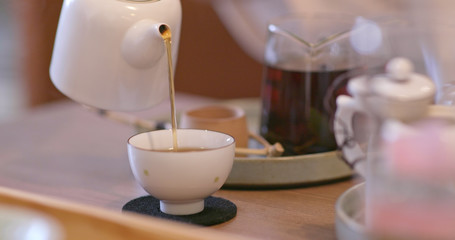 Pouring tea to a cup in restaurant