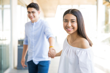 Girl Holding Boyfriend's Hand In Shopping Center