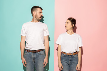 Wow. Doubtful pensive couple with thoughtful expression making choice against pink background