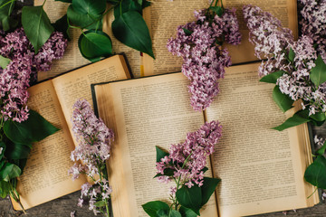 Cup of tea, lilac flowers, book on dark wooden background