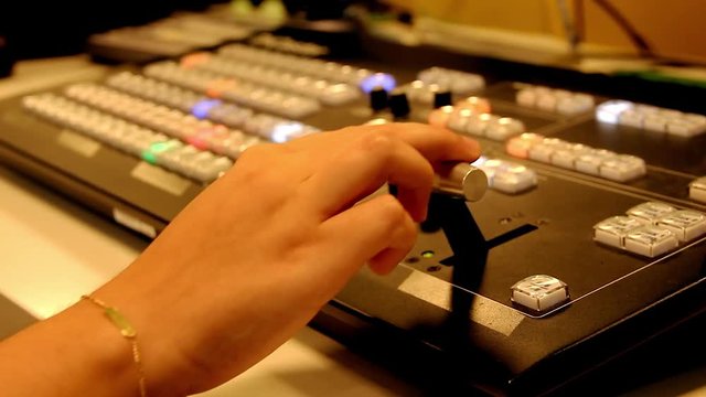 Hand of woman using television show production system. Professional equipment on studio set. Multi camera control desk. Broadcast network recording event concepts
