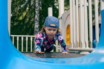 Caucasian cute girl play a slider in Playground in her schoolor kindergarten, kid and fun concept