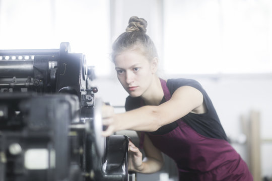 Woman operating a printing press in a factory