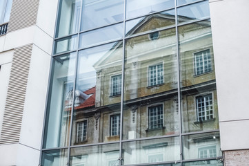 ; view of skyscraper windows; old city in the reflection of a new building;  mixture of glass, metal and concrete