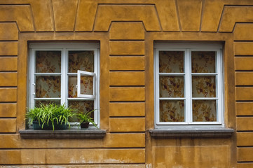 Fototapeta na wymiar old beautiful town houses; Sights of Warsaw;colorful houses with windows;windows with white frames in a yellow wall