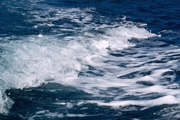 The trailing waves behind the boat while cruising on the ocean