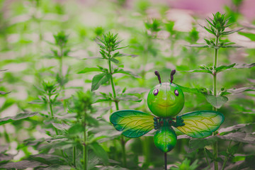 Fake insect in the garden, funny butterfly model in grass