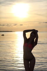 girl in bikini on background of sea sunset